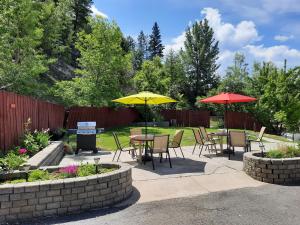 un patio con tavoli, sedie e ombrelloni di Alpen Motel a Radium Hot Springs