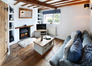 sala de estar con sofá y chimenea en Romantic Cotswold Cottage- dog friendly and village location, en Mickleton
