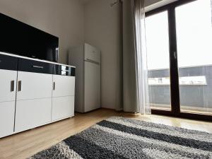 a living room with a tv and a large window at Apartments Villa Anna Sonia in Podstrana