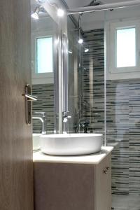 ein Bad mit einem Waschbecken und einem Spiegel in der Unterkunft Peter's cozy home in Monemvasia