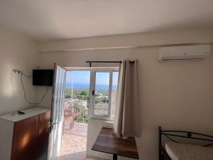 a room with a sliding glass door with a balcony at Dhoma Plazhi Husi in Himare