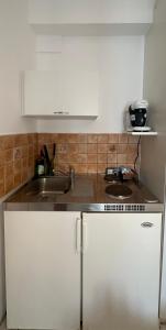 a kitchen with white cabinets and a sink at Valente Rooms Kythira in Kythira
