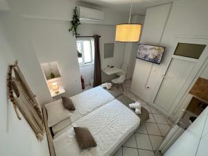 a small white bedroom with a bed and a sink at Valente Rooms Kythira in Kythira