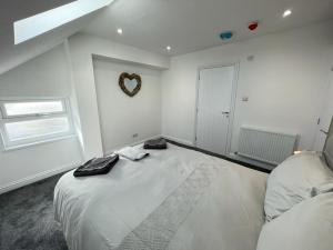 a white bedroom with a large bed and a mirror at Kimberley Holiday Apartments in Cleveleys