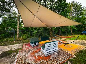 stół i krzesła na dywanie pod namiotem w obiekcie Pod Gromadzyniem Resort w mieście Ustrzyki Dolne