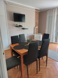 a dining room with a wooden table and chairs at Cinke Üdülőház in Tiszakécske
