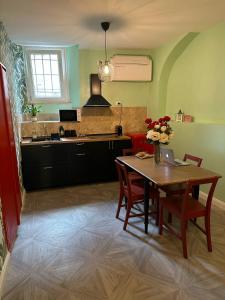 eine Küche mit einem Tisch und Stühlen sowie eine Küche mit einem Waschbecken in der Unterkunft Casetta Beatrice Tivoli Holiday Home in Tivoli