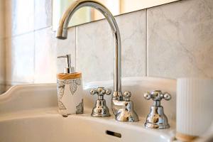 a sink with a faucet and two knobs on it at La Villa Bligny in Étretat