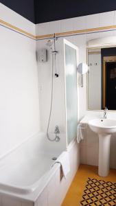 a bathroom with a tub and a sink and a shower at Hôtel de la Presqu'ile in Crozon