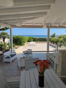 d'une terrasse avec tables et chaises et vue sur l'océan. dans l'établissement Villa vista mare, à Santo Spirito