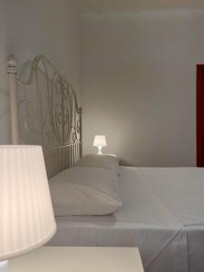 - un lit blanc avec une lampe au-dessus dans l'établissement Villa vista mare, à Santo Spirito