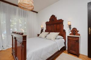 una camera da letto con letto in legno, lenzuola bianche e finestra di Zen Garden Sew View Apartment a Trogir