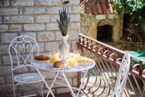 una mesa blanca con pan y zumo de naranja y un jarrón en Zen Garden Sew View Apartment, en Trogir