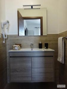 a bathroom with a sink and a mirror at FAVARA Rooms in Portopalo