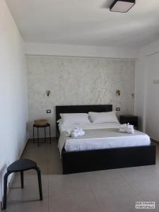 a bedroom with a large bed and a chair at FAVARA Rooms in Portopalo