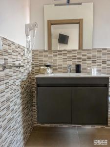 a bathroom with a sink and a mirror at FAVARA Rooms in Portopalo