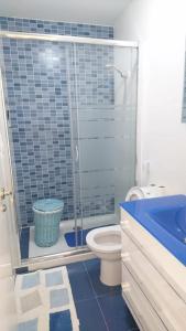 ein Bad mit einer Dusche, einem WC und einem Waschbecken in der Unterkunft Ático con piscina en palmeira in Ribeira