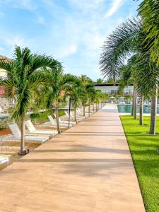 a walkway lined with palm trees in a park at Flat Completo Pipa no condominio do lle de Pipa in Pipa