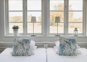 1 dormitorio con 2 camas y 2 ventanas en Blåsingsborgs Gårdshotell en Kivik