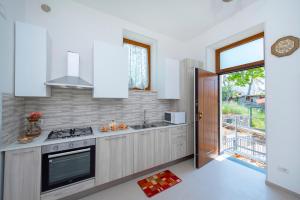 una cucina con mobili bianchi e un forno a piano cottura di LA CASETTA DEI RICORDI ad Agerola
