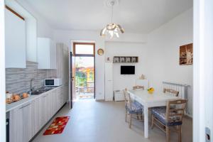 una cucina con tavolo e sedie bianchi e una cucina con finestra di LA CASETTA DEI RICORDI ad Agerola