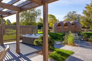 a backyard with a wooden pergola and a gazebo at Weissenhaus Private Nature Luxury Resort in Weißenhaus