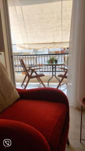 ein Wohnzimmer mit einem Sofa und einem Tisch auf dem Balkon in der Unterkunft Family Apartment in Patras