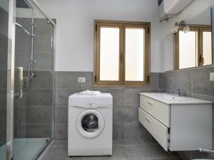 W łazience znajduje się pralka i umywalka. w obiekcie Iside Accommodations w mieście Olbia