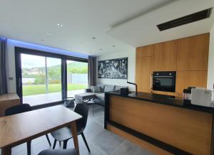 a kitchen and living room with a table and chairs at Pláž Hrdlička in Buš
