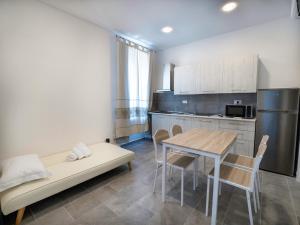 a kitchen and dining room with a table and a couch at Iside Accommodations in Olbia