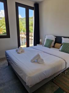 een groot bed met twee handdoeken erop bij Hotel L'Escale in Porto Pollo