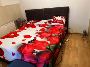 魯爾河畔米爾海姆的住宿－CHEAP ROOM IN A SHARED APARTMENT IN Mulheim, GERMANY，一张在房间内装有红色花的床铺