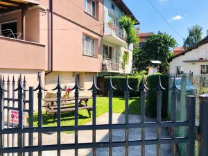 a fence in front of a building with a picnic table at Pavlovi Apartments in Samokov