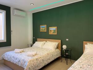 1 dormitorio con 2 camas y pared verde en Liu' al viale, en Agrigento