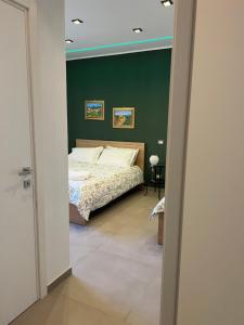 ein Schlafzimmer mit einem Bett und einer grünen Wand in der Unterkunft Liu' al viale in Agrigento