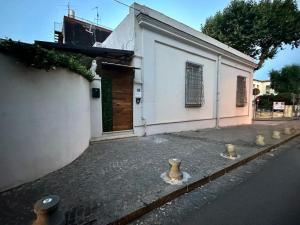 a white building with vases on the side of a street at Olympus Pompei Rooms in Pompei