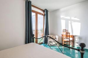 a bedroom with a bed and a window and a chair at Villa Lena in Conca dei Marini