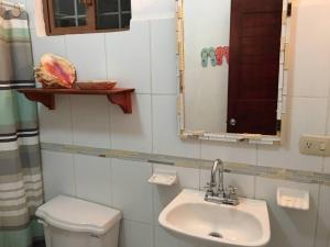 ein Badezimmer mit einem Waschbecken, einem WC und einem Spiegel in der Unterkunft Casita Sac-Nicté in Mahahual
