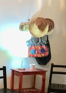 einem Tisch mit einem Hut an einer Wand neben einem Tisch mit einem Sechseck in der Unterkunft Casita Sac-Nicté in Mahahual