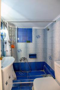 ein blau gefliestes Bad mit einer Dusche und einem Waschbecken in der Unterkunft Evie's cozy apartment in Athen