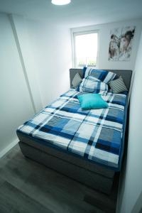 ein Schlafzimmer mit einem Bett mit einer blauen karierten Decke in der Unterkunft Barockes Refugium I 10 Minuten zum Europa-Park in Ettenheim
