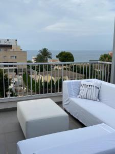 a balcony with two white couches and the ocean at Àtico Espuma - Marenia´s Dream in Denia