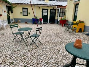 un patio con mesas y sillas en un suelo de ladrillo en Julias Pateo, en Carcavelos