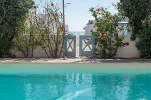 a pool of water with a gate and flowers at Monolithos Pool Villa by the Beach in Monolithos