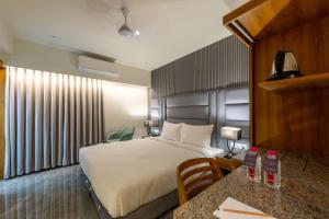 a hotel room with a bed and a table at Hotel Nalanda in Ahmedabad