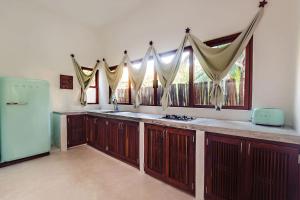 a kitchen with wooden cabinets and a large window at Mi Kasa Tu Kasa Bacalar by Nah Hotels in Bacalar