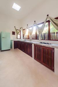 a kitchen with wooden cabinets and a refrigerator at Mi Kasa Tu Kasa Bacalar by Nah Hotels in Bacalar