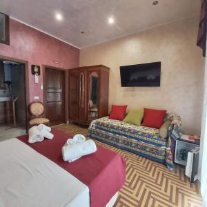 Habitación de hotel con 2 camas y sofá en Bed and Breakfast Dolce Noemi, en Reggio Calabria
