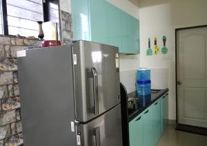 eine Küche mit einem Kühlschrank aus Edelstahl und einer Theke in der Unterkunft Bluebeli Mountain Villa By Holiday Villass in Mahabaleshwar + 33 Fotos