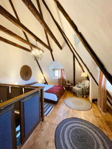 a attic room with a bed and a rug at Inside, The Village- Rooster's Nest 